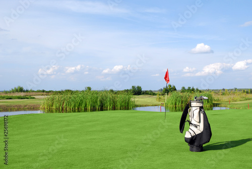 golf field with flag and golf bag