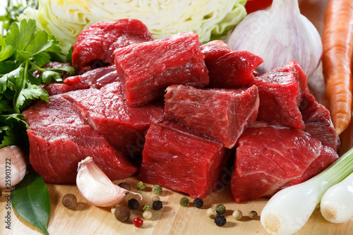 Raw beef on cutting board and vegetables