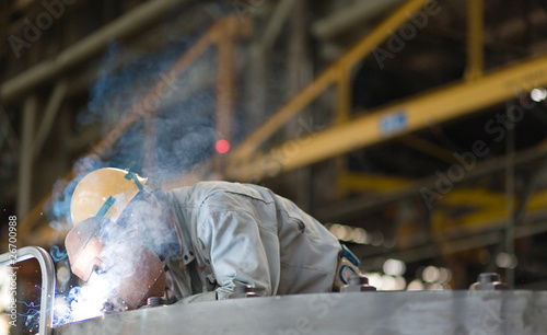 Heavy industry manual worker welding/grinding in a factory