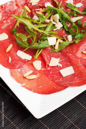 carpaccio on a plate with parmesan and pignolia