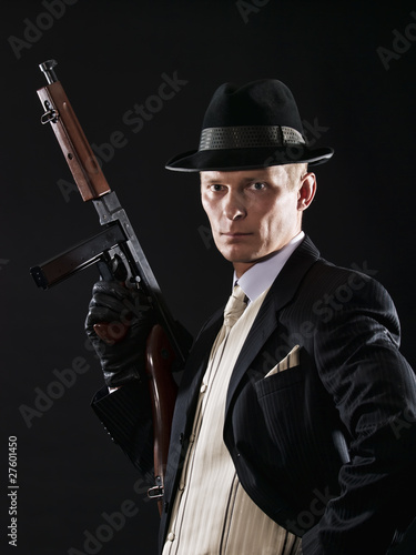 Man like a chicago gangster in suit with Thompson submachine gun