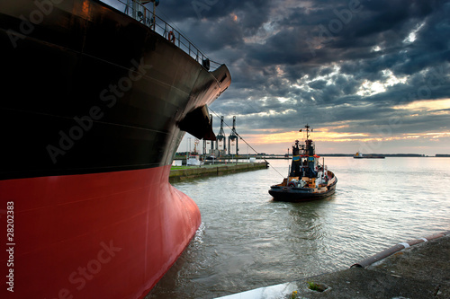 Tug boat taking out the ship from the harbor