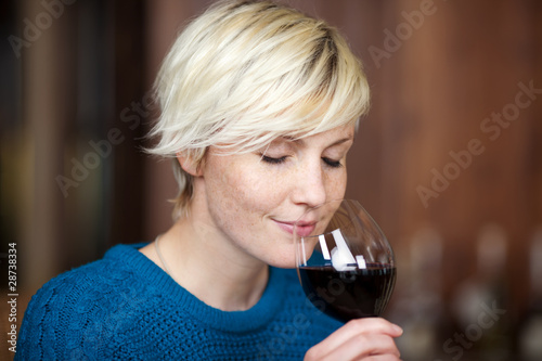 junge blonde frau genießt rotwein