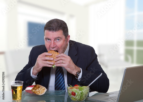 man at office working and eat unhealthy fast food