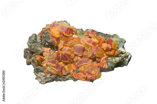 Red realgar crystals with orpiment on white, arsenic mineral.