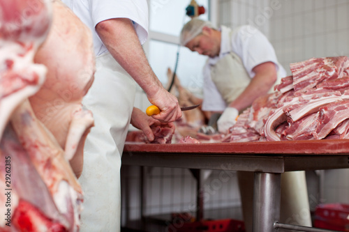 zwei metzger zerlegen fleisch