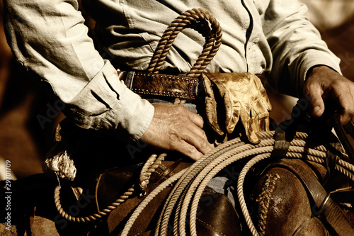 Real working cowboy riding in sunset light (sepia tint)