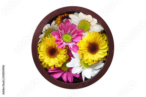 A wooden bowl filled with water and flowers