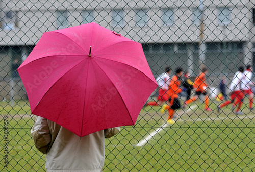 Parent observes young players in the rain