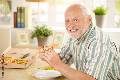 Portrait of senior having pizza