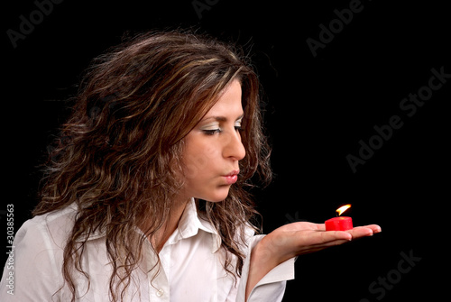 Young woman blowing out candle