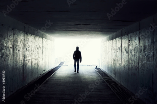 Silhouette of Man Walking in Tunnel. Light at End of Tunnel