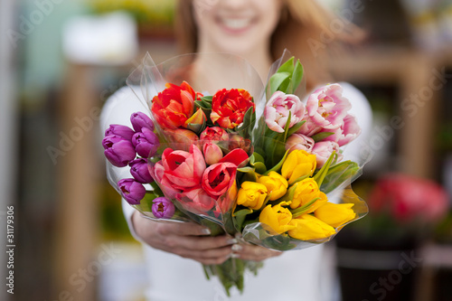 frau zeigt blumen vom markt