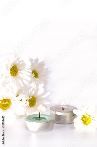 Simple white daisy and two candles with isolated white backgroun