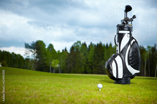 golf equipment on green and hole as background