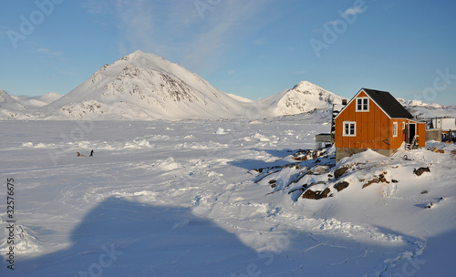 Yellow cottage and dog in winter, Greenland