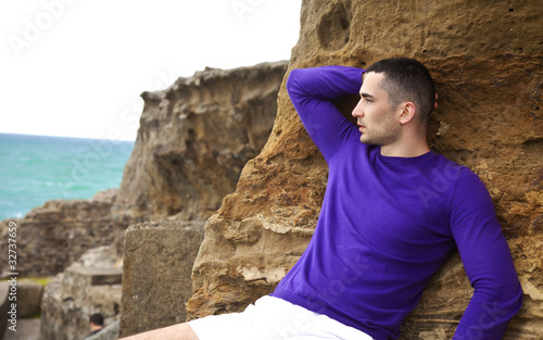 man laying on the rocks and watching the sunset