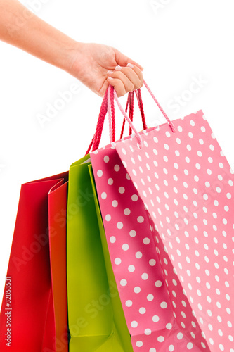 close-up of female hand holding colorful shopping bags