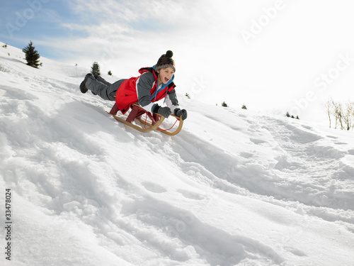 Pre-teen Boy On A Sled In The Snow