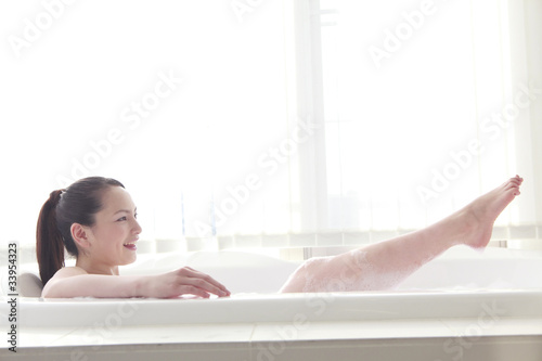 泡のお風呂で寛いでいる女性