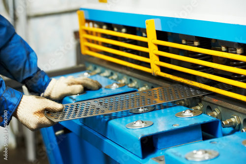 worker's hand operating guillotine shears machine