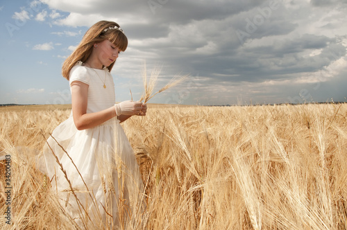 girl wearing first communion dress between barley