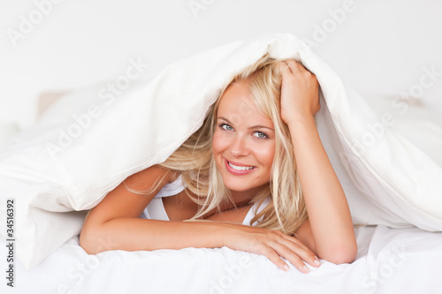 Smiling woman under a duvet