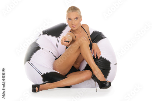 Woman with remote control in chair of soccer ball