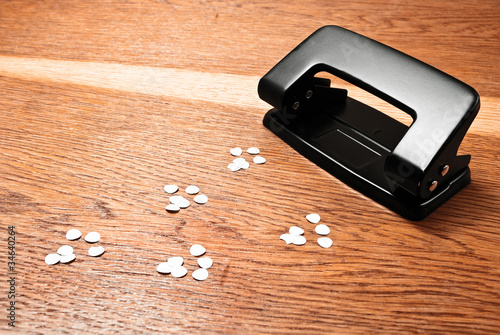 Hole puncher on a wooden background.