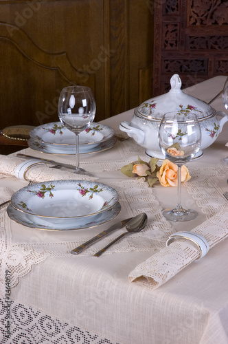 Piękne porcelanowe nakrycie stołu w restauracji przykrytego koronkowym obrusem