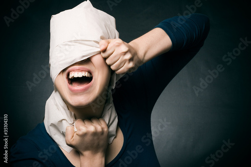 Young woman's head wrapped in paper.