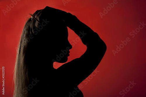 profilo nero di una giovane donna bionda su sfondo rosso