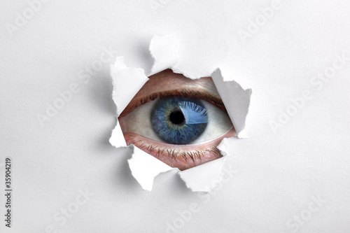 Looking through a hole in white paper