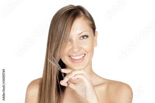 Attractive happy young woman is cutting her long natural hair