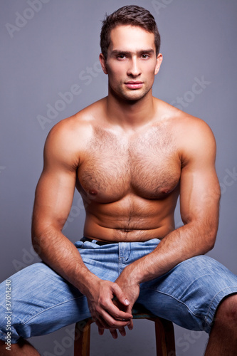 muscular man sitting on a chair