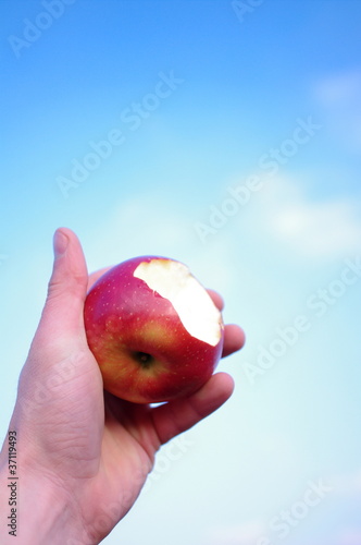 Nadgryzione jabłko na tle nieba