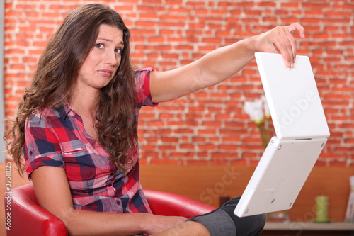 Woman holding her laptop disdainfully