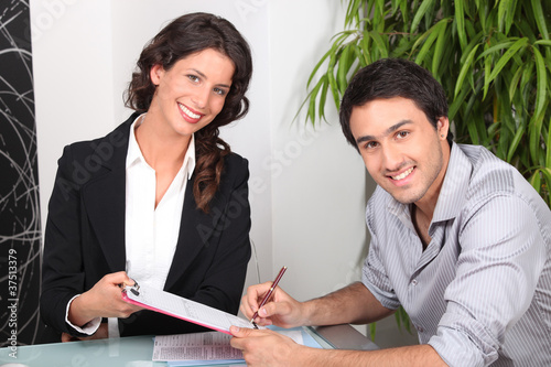 female real estate agent and young man buying house