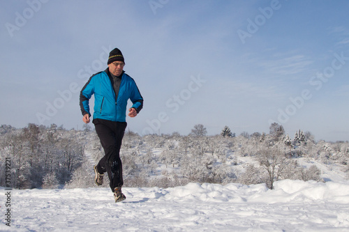 Senior joggt in schneebedeckter Winterlandschaft