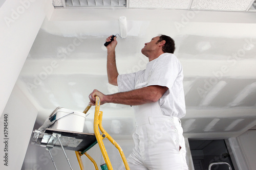 Tradesman painting a ceiling