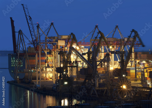 cranes at the container port terminal in sunset time