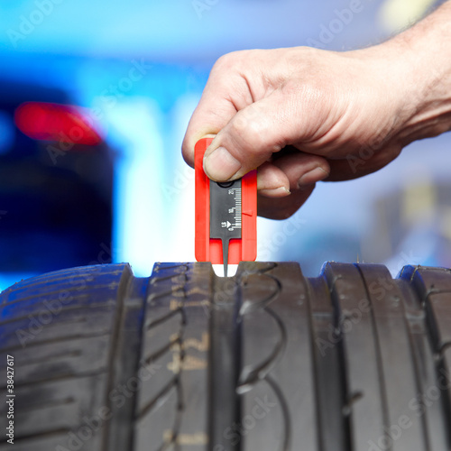 Checking the tread pattern depth of a summer tyre in a garage