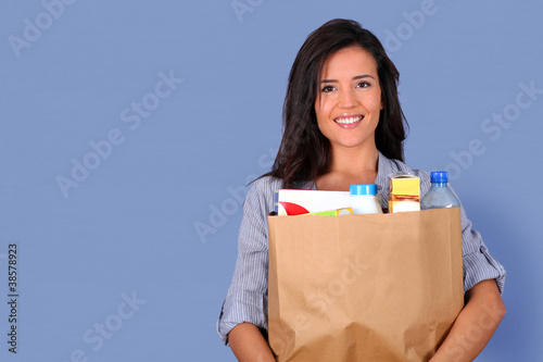 Young woman carrying bag of grocery