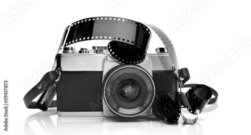 Old 35mm film photo camera on white background with 35mm film st