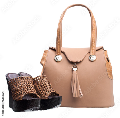 Pair of women open-toe clogs and handbag over white
