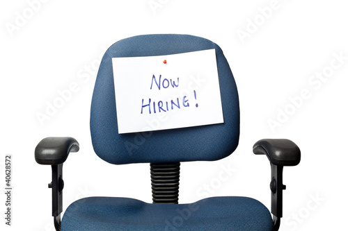 Office chair with a NOW HIRING sign isolated on white