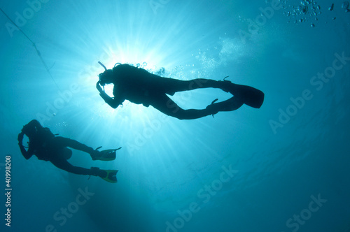 sihlouetted scuba divers