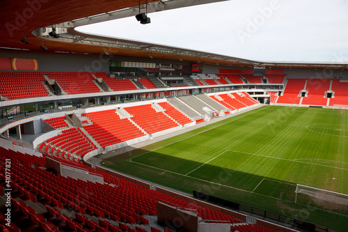 View on an empty football (soccer) stadium with red seats