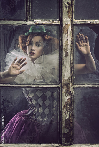 A lonely pierrot woman behind the glass