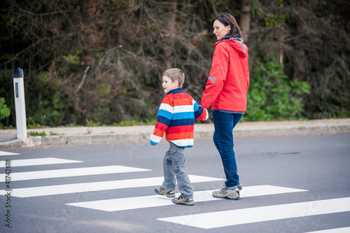 Mutter und Sohn überqueren Strasse